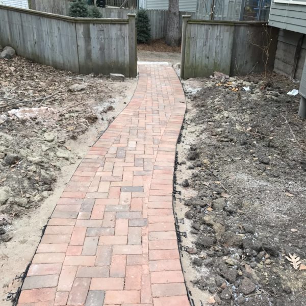 Brick pathway leading through backyard